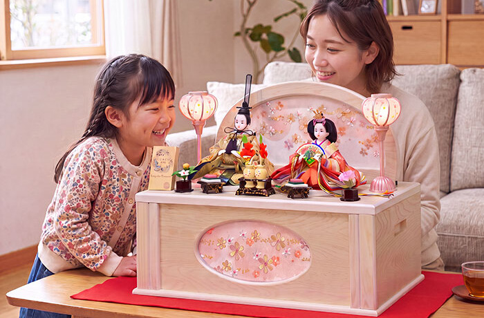 雛人形のホワイト収納セットを見ている親子の画像