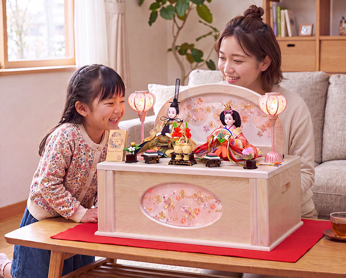 雛人形のホワイト収納セットを見ている親子の画像