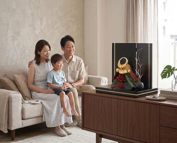 五月人形の兜飾りの平飾りを親子で見ている画像
