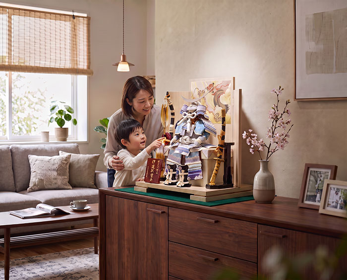 五月人形の鎧飾りを親子で見ている画像